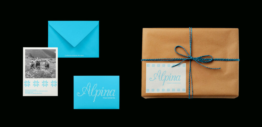 photo sur fond noir d'une enveloppe bleu, avec une carte de remerciement et un emballage d'envoi